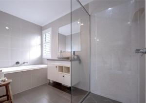 a bathroom with a shower and a sink and a tub at Lamington Cottage in The Range