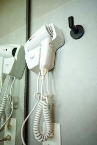 Ein Haartrockner hängt neben einem Telefon an der Wand. in der Unterkunft Miragem Noronha in Fernando de Noronha