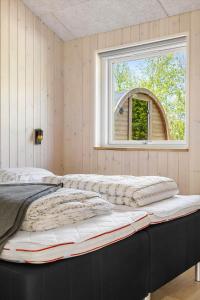 a large bed in a room with a window at 0370-Romo-Vestergardsvaenget-13 in Høm
