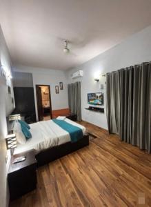 a bedroom with a large bed and wooden floors at Krishna Kunj Resort in Chhatikara