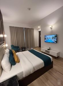 a hotel room with a bed and a tv on the wall at Krishna Kunj Resort in Chhatikara