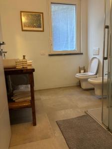 a bathroom with a toilet and a window at Kaspers home lake Como in Blevio +22 photos