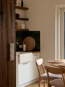 a kitchen with a table and a white counter top at Domek Las&Luz Moszna BALIA in Moszna +52 photos