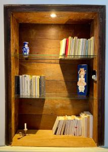 a wooden book shelf with books on it at Le Cocand in Autun