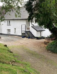 a white house with a staircase in front of it at Corner Lodge in North Tawton
