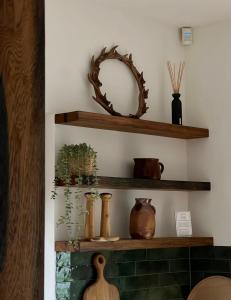 a shelf with vases and a mirror on a wall at Domek Las&Luz Moszna BALIA in Moszna