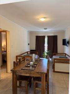 a dining room with a table and a bed at Complejo Pampa 1 in Santa Rosa