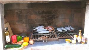 a grill with meat and vegetables and meats on at Pensao Porta do Vento in Santa Maria
