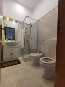a bathroom with a toilet and a shower and a sink at Lolli Station House in Palermo +7 photos