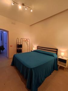 a bedroom with a bed with a green blanket and lights at Lolli Station House in Palermo