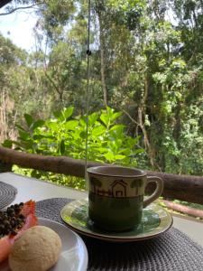 a cup of coffee and a plate of food on a table at Pousada ROCA in Ibiúna