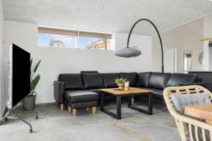 a living room with a black couch and a table at 0364-Romo-Vestergardsvaenget-7 in Høm