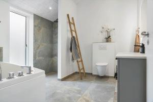 a bathroom with a tub and a toilet and a ladder at 0364-Romo-Vestergardsvaenget-7 in Høm +43 photos