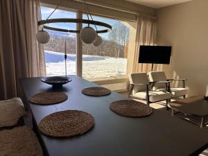 a table in a living room with a large window at Leilighet på Hovden in Bykle