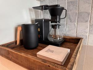 a coffee maker on a wooden tray with a book at Leilighet på Hovden in Bykle