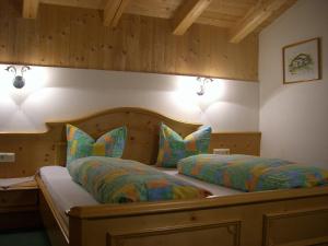 a bedroom with a bed with colorful sheets and pillows at Jagahäusl in Neustift im Stubaital