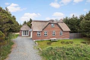 a red brick house with a thatched roof at 0123-Romo-Ivigtut-9 in Høm