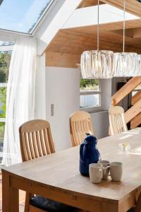 a dining room table with chairs and a blue kettle on it at 2005-Romo-Thadesvej-14 in Høm