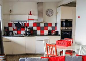a kitchen with a red and white checkered wall at Casinha de Nesquim in Calheta de Nesquim