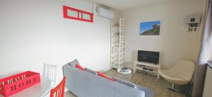 a small living room with a couch and a television at Casinha de Nesquim in Calheta de Nesquim