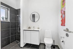 a white bathroom with a toilet and a mirror at 0323-Romo-Vestergade-359 in Høm