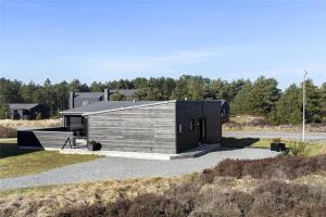 a house with a black roof on a road at 0323-Romo-Vestergade-359 in Høm