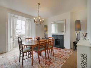 a dining room with a table and chairs and a fireplace at 7 Athol Terrace in Dover