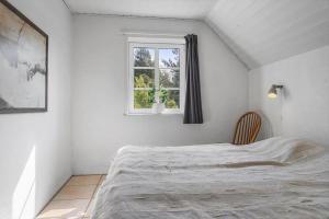 a white bedroom with a bed and a window at 2008-Romo-Froidal-10 in Høm