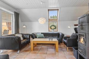 a living room with black leather furniture and a table at 2008-Romo-Froidal-10 in Høm
