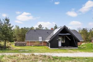 a black house with a garage in a field at 2008-Romo-Froidal-10 in Høm