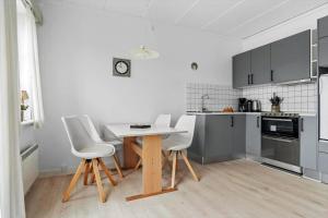 a kitchen with a table and white chairs in it at 0459-Romo-Vestergade-237-App-64 in Høm