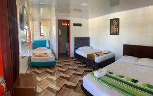 a hotel room with two beds and a bathroom at Finca Tradicional La Rochela in Montenegro