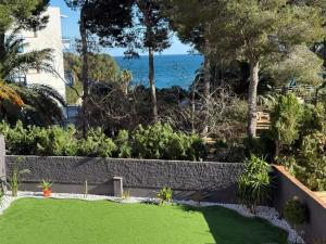 a garden with green grass and the ocean in the background at Evian Cala in Miami Platja