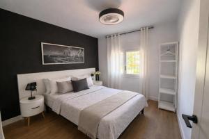 a bedroom with a large bed with a black wall at Evian Cala in Miami Platja +14 photos