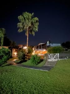 a palm tree in front of a house at night at Sole Luna in Río Ceballos +2 photos