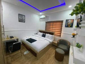 ein Schlafzimmer mit einem Bett, einem Schreibtisch und einem Stuhl in der Unterkunft Mathelm Hotel in Ikorodu