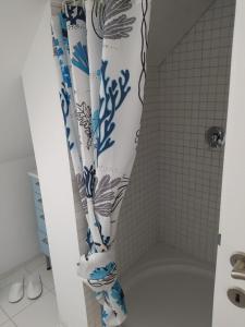 a shower with a blue and white shower curtain at Villa Siegrid in Kremsmünster