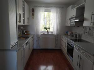 a kitchen with white cabinets and a sink and a window at Villa Siegrid in Kremsmünster
