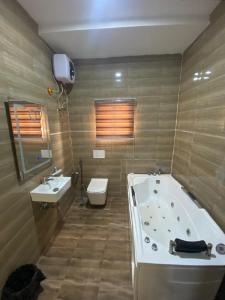 ein Badezimmer mit Badewanne, Toilette und Waschbecken in der Unterkunft Mathelm Hotel in Ikorodu