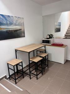a kitchen with a table and stools and a microwave at Piata Uniri Cozy Inn in Bucharest