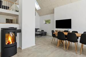 a living room with a fireplace and a table and chairs at 2007-Romo-Juvrevej-43 in Høm