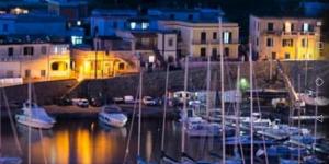 a group of boats docked in a marina at night at Grande Procida in Procida