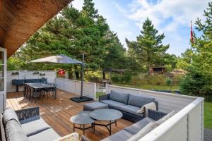 a patio with a couch and a table on a deck at 2805-Romo-A-Hveyselsvej-8 in Høm