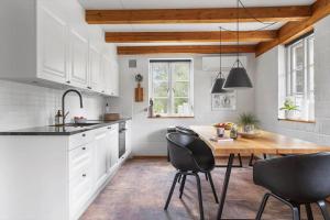 a kitchen with a wooden table and black chairs at 2805-Romo-A-Hveyselsvej-8 in Høm