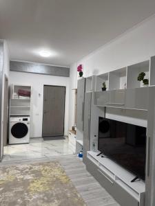a white kitchen with a fireplace and a door at Garsonieră in Tulcea