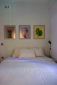 a bedroom with a bed with four pictures on the wall at live it _ Karditsa in Karditsa