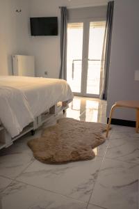 a bedroom with a bed and a rug and a window at live it _ Karditsa in Karditsa