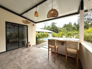 an outdoor kitchen with a table and chairs in a house at Lalola de Puerto in Puerto Viejo