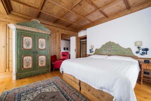 a bedroom with a bed and a green cabinet at Hotel Cortina in Cortina dʼAmpezzo +109 photos