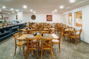 a dining room with wooden tables and chairs at El Aram Natal Mar in Natal +41 photos